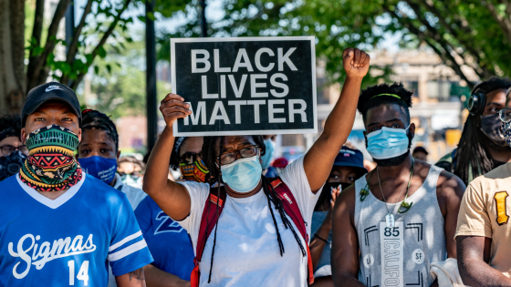 A Black Lives Matter protester holds sign during a rally at Nubian Square in Boston