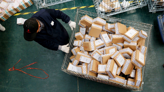 A Chinese worker carts parcels, most of which are from online shopping, at the warehouse of an e-commerce company