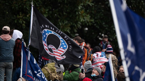 A Qanon flag flies among Trump supporters storming the United States Capitol