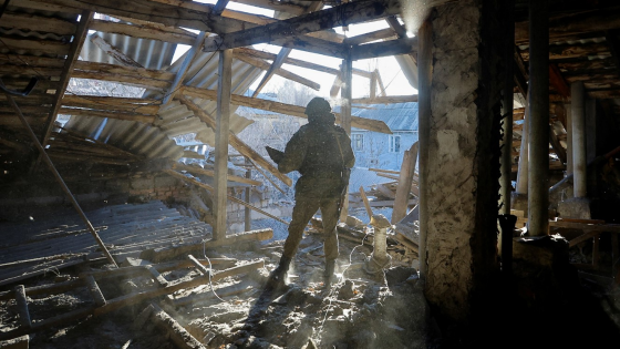 A Russian military investigator works inside a residential building heavily damaged in recent shelling in the course of the Russia-Ukraine conflict