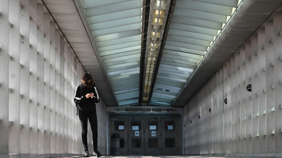 A Stuyvesant High School student looks at her smart phone while crossing the Tribeca bridge in New York