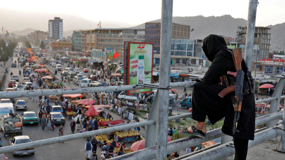 A Taliban fighter stands guard on a bridge in Kabul, Afghanistan