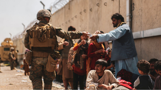 A U.S. Marine passes out water to evacuees during an evacuation at Hamid Karzai International Airport