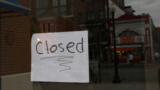 A closed sign on the window of a business during the outbreak of COVID-19.