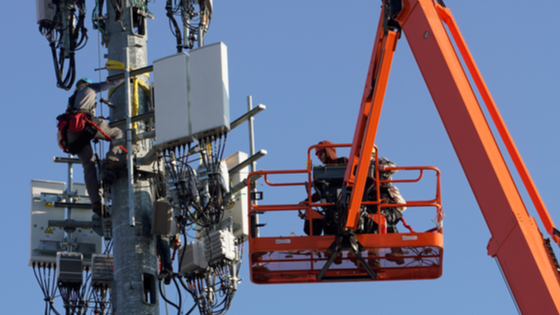 A contract crew from Verizon installs 5G equipment on a tower in Orem