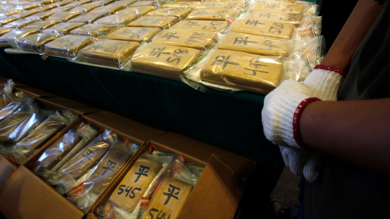 A customs officer stands beside a total of 1,430 pounds of cocaine during a news conference