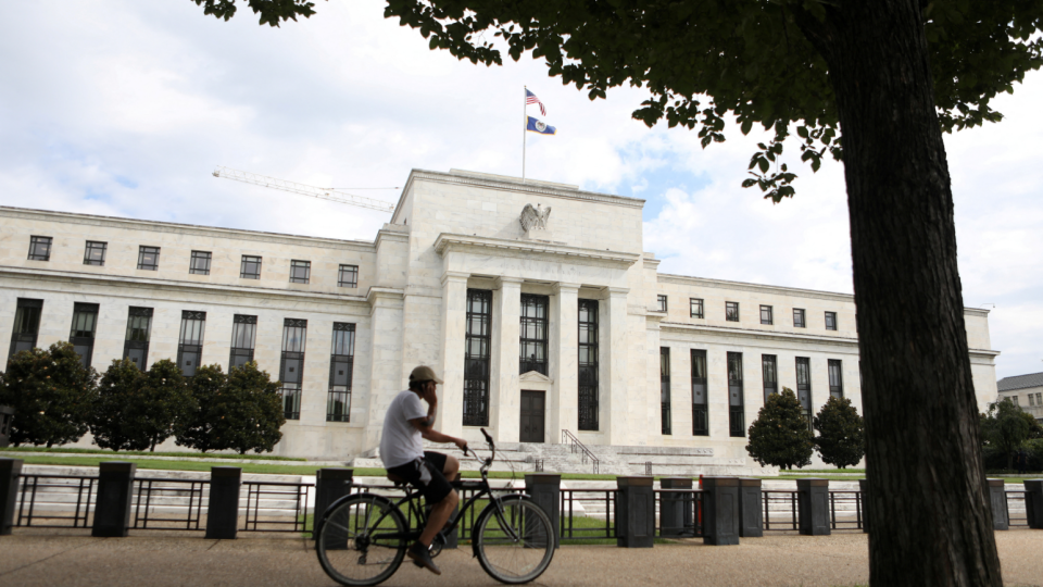 A cyclist passes the Federal Reserve building in Washington, DC