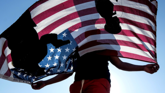 A demonstrator holds a flag during a protest against the death of 18-year-old Andres Guardado and racial injustice, in Compton, California