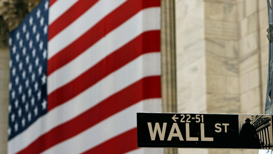 A flag is seen behind a street sign for Wall St