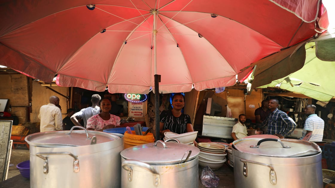 A food vendor arranges her sets of pots and plates on a table in Abuja, Nigeria