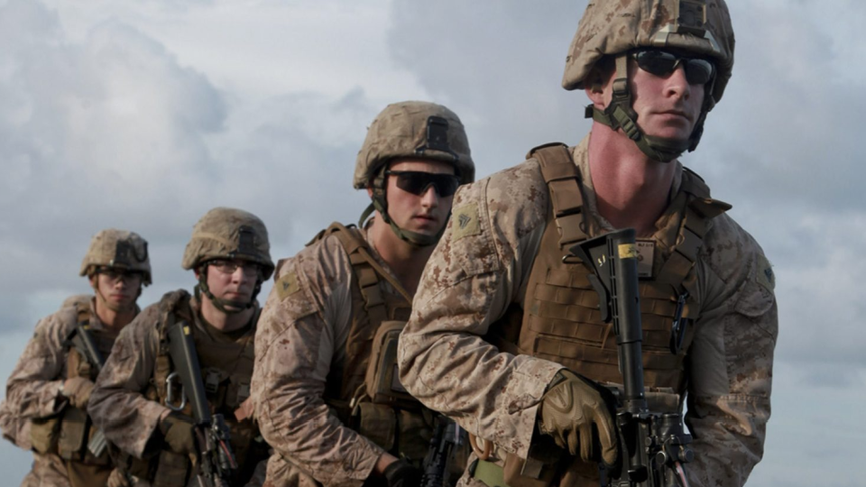 A group of U.S. soldiers line up in a row.