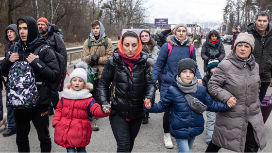 A group of Ukrainian refugees walk down street