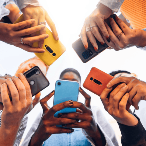 A group of people holding phones together