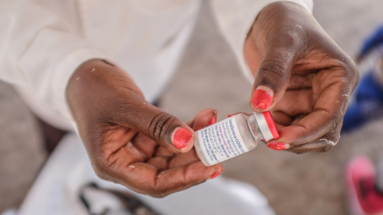 A health worker holds an Oxford-AstraZeneca COVID-19 vaccine vial