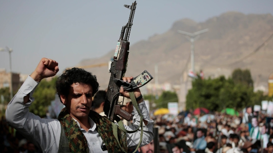 A houthi supporter carries a weapon during a protest against USA and Saudi Arabia.