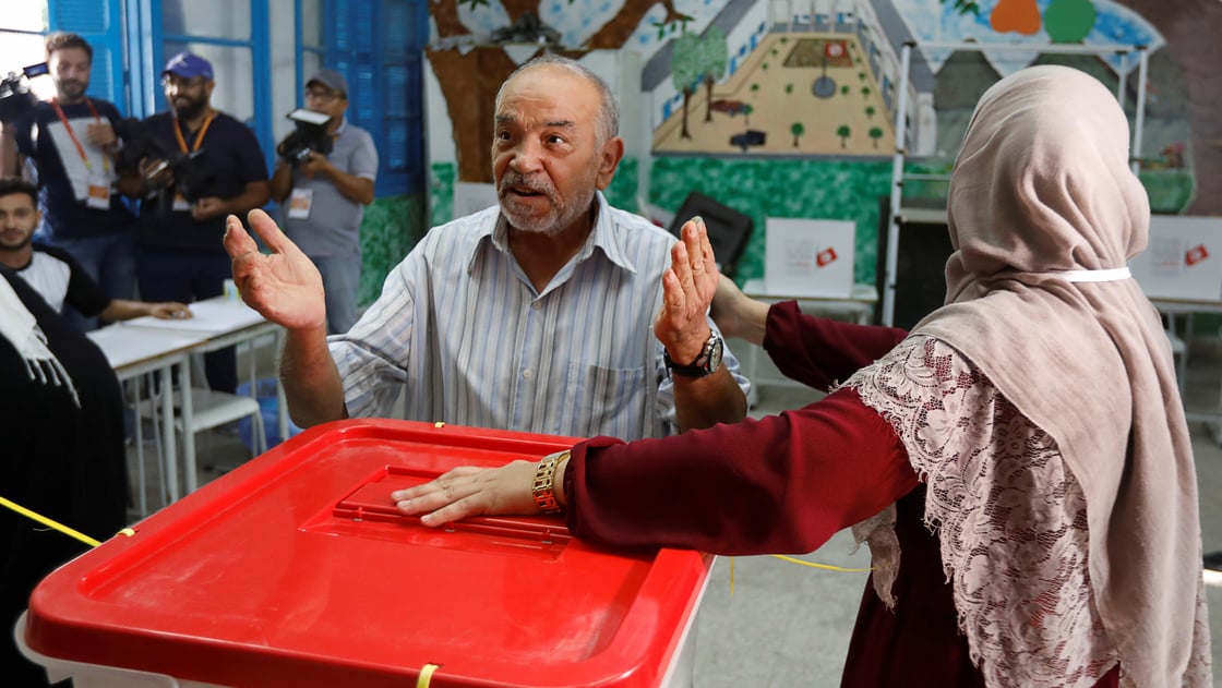 A man gestures after casting his ballot at a polling station during parliamentary elections, in Tunis, Tunisia