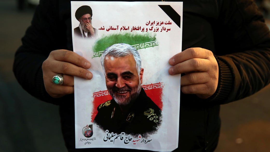 A man holds a picture Iranian Major-General Qassem Soleimani