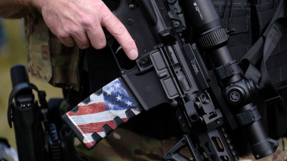 A man holds an assault rifle as Proud Boys gather in Portland