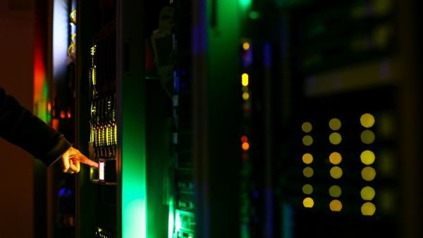 A man poses inside a server room at an IT company