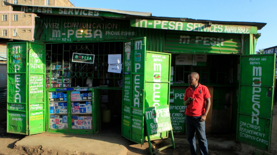 A man waits for M-Pesa customers at his shop in Kibera