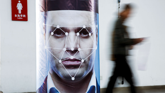 A man walks past a poster simulating facial recognition software at the Security China 2018 exhibition on public safety and security