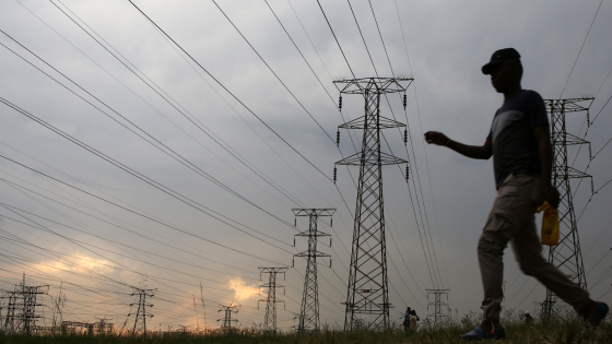 A man walks past electricity pylons in Soweto