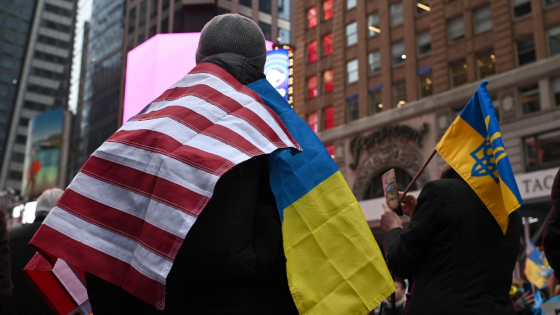 A man wearing both a U.S. flag and a Ukrainian flag attends a rally in Times Square