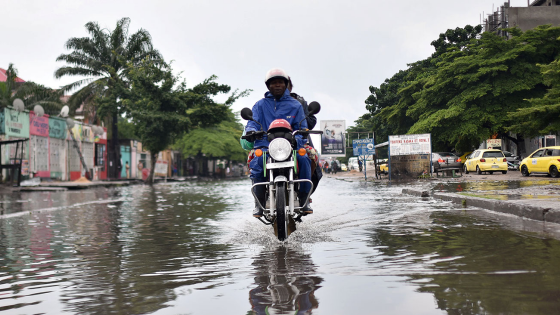 A motorcyclist rides through a flooded road during the presidential election in Kinshasa