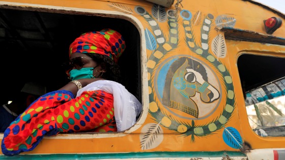 A passenger wearing a face mask sits on bus