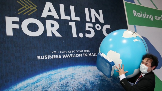 A person carries a globe model during the UN Climate Change Conference in Glasgow