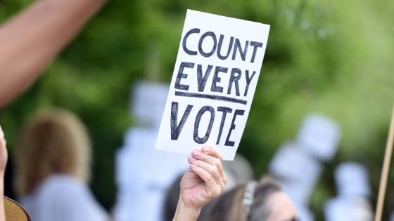 A person holding Count Every Vote sign