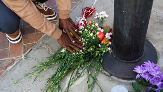 A person lays down flowers as members of the community hold a prayer vigil near the scene of a shooting in Monterey Park, California