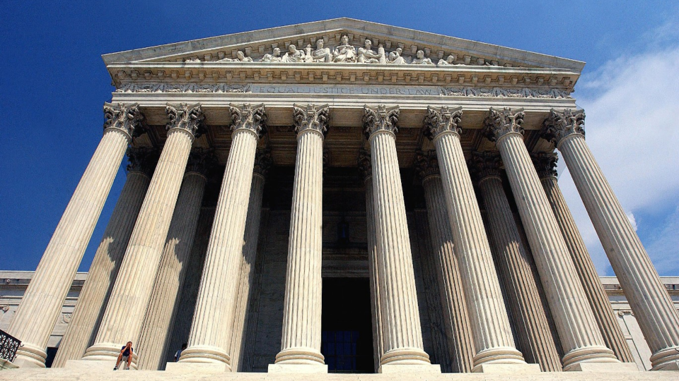 A person sits on a step of the U.S. Supreme Court building