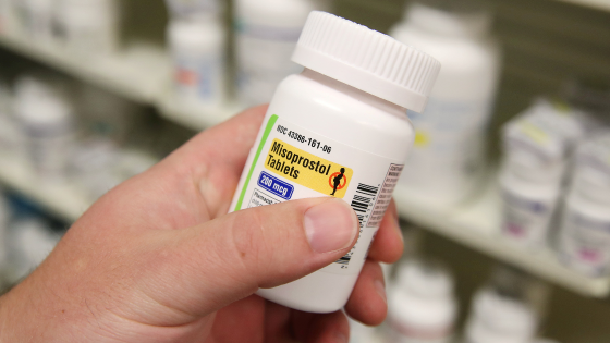 A pharmacist shows a bottle of the drug Misoprostol
