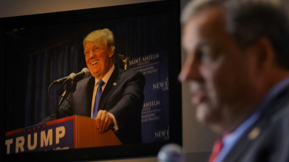 A photograph of Donald Trump hangs on the wall as Chris Christie speaks at the Institute of Politics at St. Anselm College