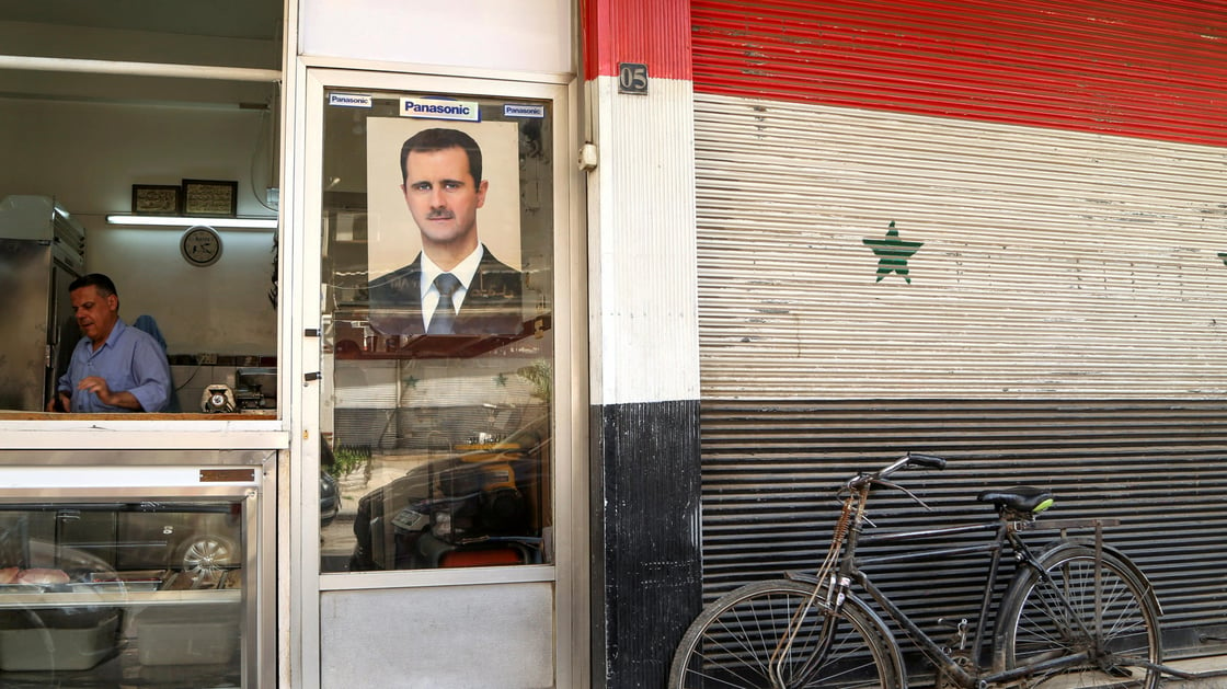 A picture of Syrian President Bashar al-Assad is seen on a door of a butcher shop