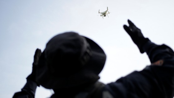 A police officer uses a drone during a search for skeletal remains and clothing at a plot of land