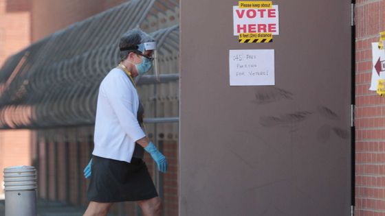 A poll worker wears PPE at a polling station at ASU.
