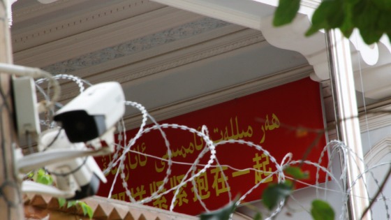 A propaganda banner and a security camera are placed on the walls of a mosque in the Old City in Kashgar