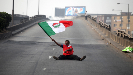 A protester waves a flag on an empty road during a protest against a fuel subsidy removal in Lagos