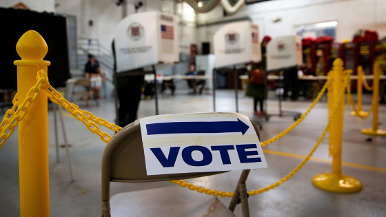 A sign points towards voting booths during the midterm election at Philomont Fire Station