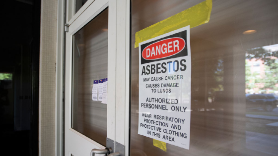 A sign warns of asbestos on the doorway to the office tower at 215 W. Oak St. in Fort Collins