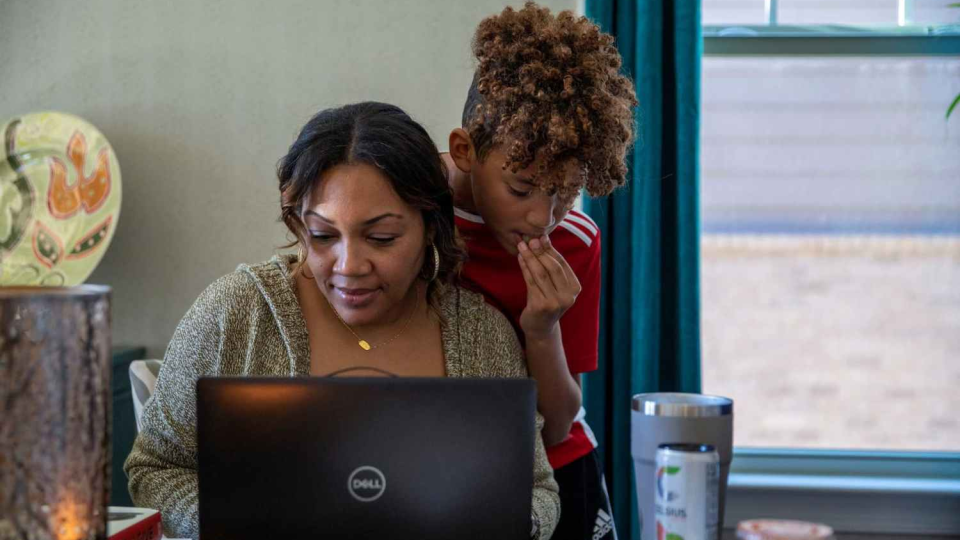 A student and his mother during a remote learning school day at home.