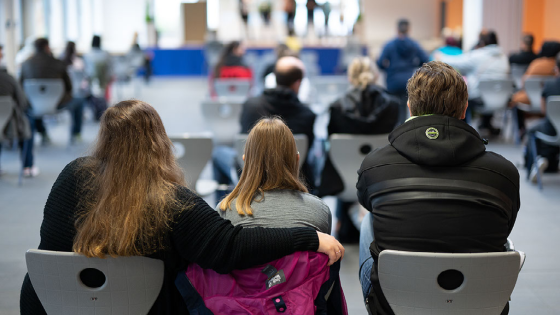 A student attends the enrollment of a fifth grade class at Alteburg School with her parents