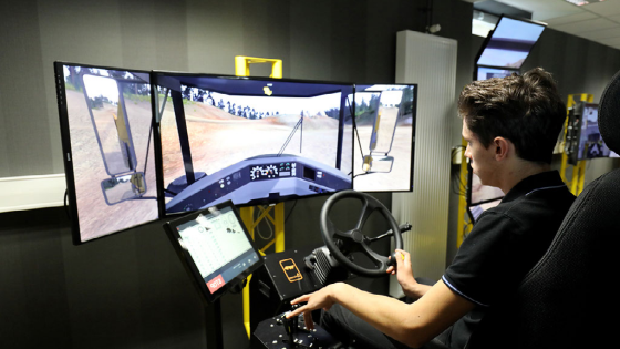 A student uses a driving simulator for civil engineering machines