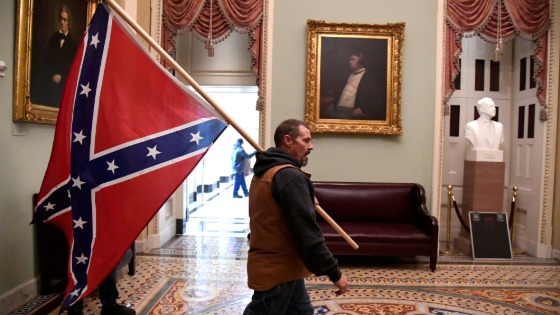 A supporter of President Donald Trump carries a Confederate battle flag on the second floor of the U.S. Capitol