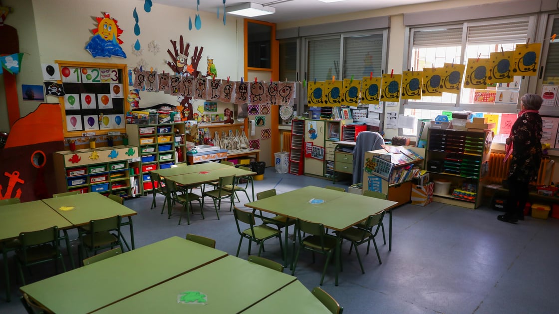 A teacher raises a shutter inside an empty classroom in a closed school in Madrid.