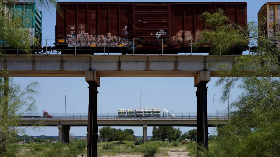 A train and truck cross into the United States from Mexico on May 26, 2022 in Eagle Pass, Texas