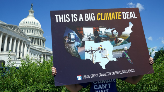 A volunteer holds a placard during a news conference on the climate crisis and the Inflation Reduction Act at the U.S. Capitol