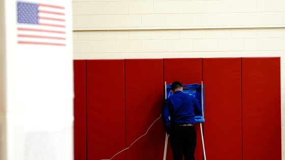 A voter completes his ballot inside a privacy booth